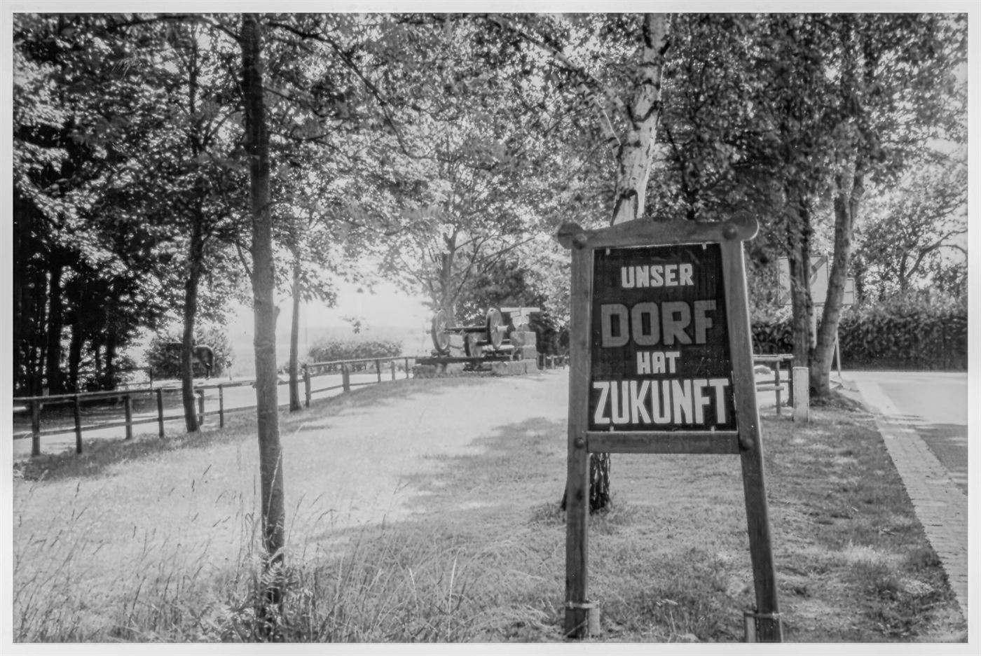 Das alte Holzschild am Ortseingang mit der Aufschrift Unser Dorf hat Zukunft